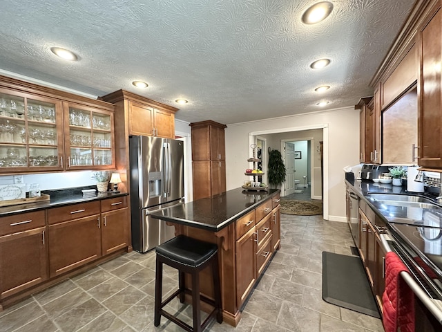 153 Pine Trail Rd, London, KY 40744 - kitchen featuring appliances with stainless steel finishes, dark countertops, a kitchen island, glass insert cabinets, and ornamental molding