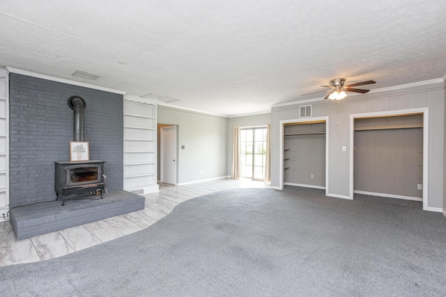 9581 Harrodsburg Rd, Wilmore, KY 40390 - unfurnished living room featuring a wood stove, a ceiling fan, a textured ceiling, crown molding, and built in shelves