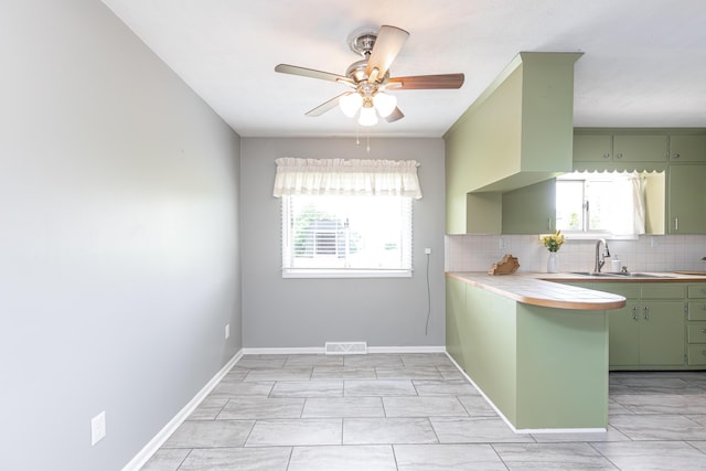 9581 Harrodsburg Rd, Wilmore, KY 40390 - kitchen featuring green cabinets, decorative backsplash, ceiling fan, and a peninsula