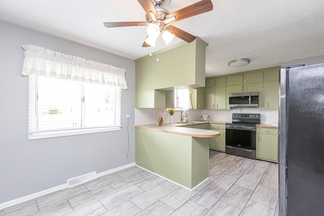 9581 Harrodsburg Rd, Wilmore, KY 40390 - kitchen with appliances with stainless steel finishes, green cabinetry, a peninsula, light countertops, and decorative backsplash