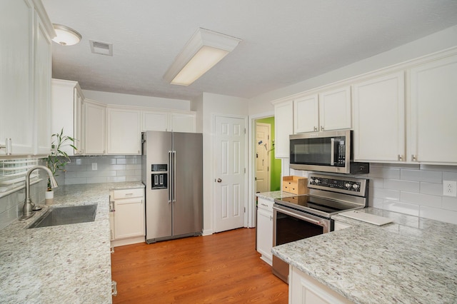 1280 Kennecott Way, Lexington, KY 40514 - kitchen featuring appliances with stainless steel finishes, backsplash, light wood-style floors, and white cabinetry