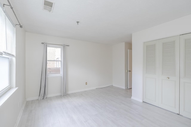 421 Redding Rd Unit 56, Lexington, KY 40517 - unfurnished bedroom with light wood-style flooring, a closet, baseboards, and a textured ceiling