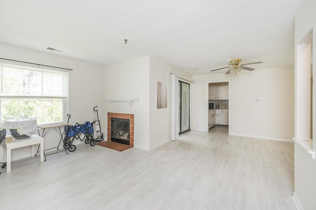 421 Redding Rd Unit 56, Lexington, KY 40517 - living room with light wood-type flooring, a ceiling fan, a tile fireplace, and baseboards