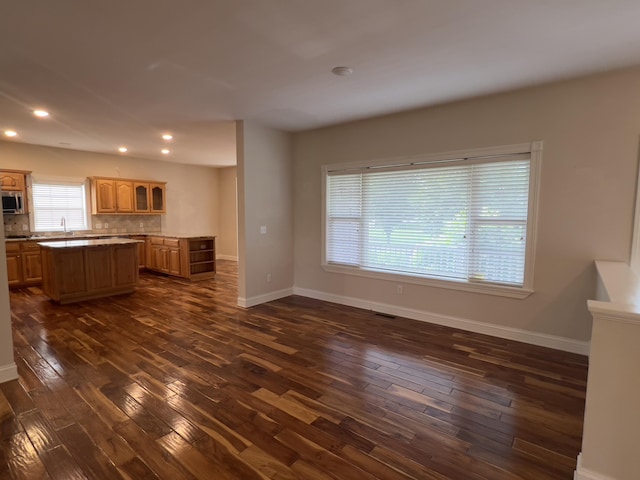 131 Betsy Ross Ln, Danville, KY 40422 - kitchen with stainless steel microwave, a center island, dark wood-style floors, baseboards, and backsplash