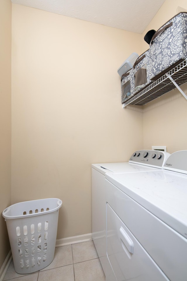 3008 Roundway Down Ln, Lexington, KY 40509 - laundry area featuring washing machine and clothes dryer, light tile patterned floors, and baseboards