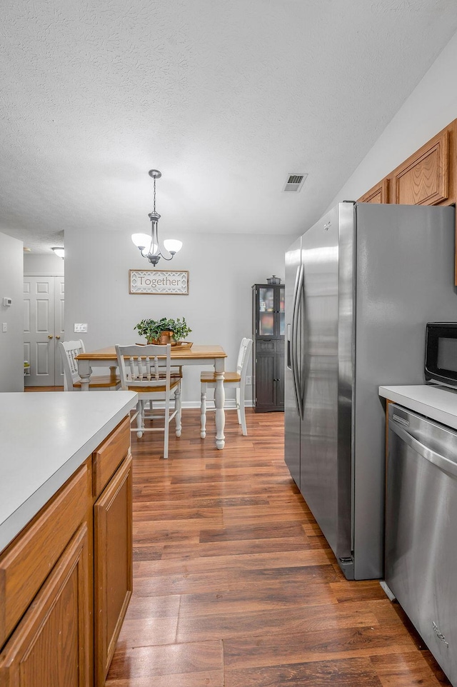 1416 Equine Way, Frankfort, KY 40601 - kitchen featuring stainless steel appliances, wood finished floors, light countertops, brown cabinets, and a textured ceiling