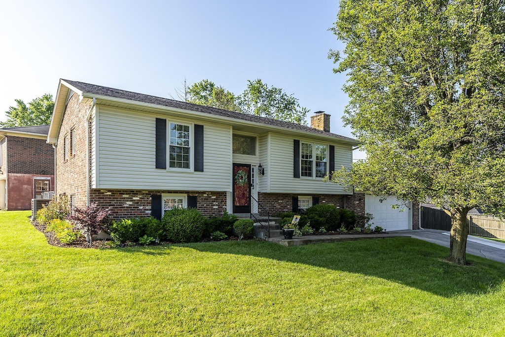 4029 Elora Ln, Lexington, KY 40515 - raised ranch with a garage, a chimney, driveway, and a front lawn
