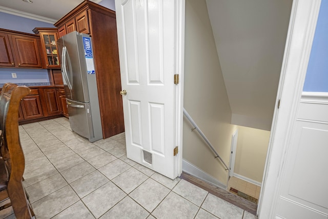 1369 Saddle Club Way, Lexington, KY 40504 - kitchen featuring freestanding refrigerator, light tile patterned floors, glass insert cabinets, ornamental molding, and brown cabinetry