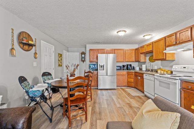 416 Scottsdale Cir, Lexington, KY 40511 - kitchen with white appliances, under cabinet range hood, light wood finished floors, brown cabinetry, and a textured ceiling
