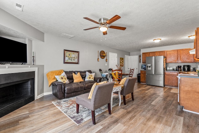 416 Scottsdale Cir, Lexington, KY 40511 - living room featuring a ceiling fan, wood finished floors, a fireplace, and a textured ceiling