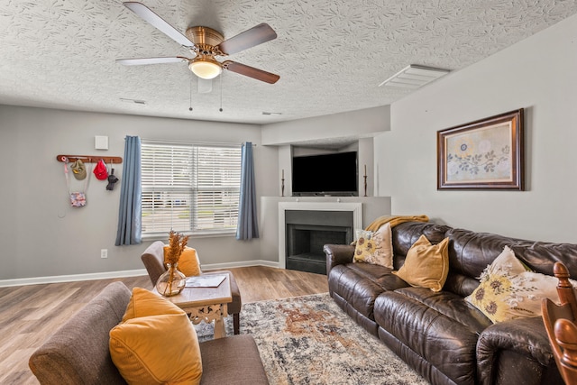 416 Scottsdale Cir, Lexington, KY 40511 - living area with light wood-style flooring, a ceiling fan, a fireplace, and a textured ceiling
