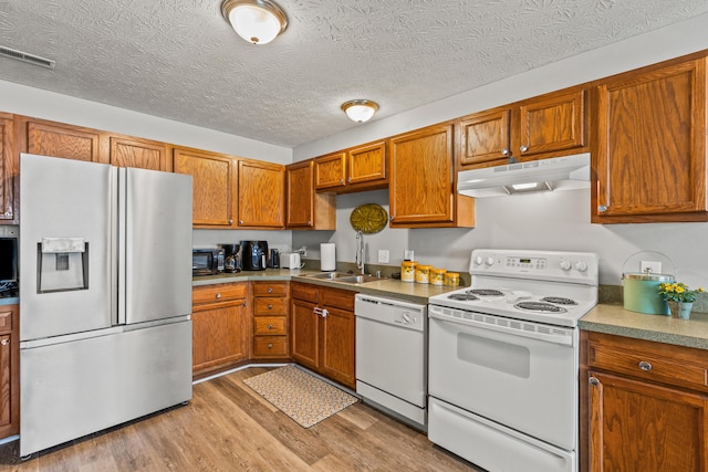 416 Scottsdale Cir, Lexington, KY 40511 - kitchen with white appliances, under cabinet range hood, light wood-style flooring, brown cabinets, and a textured ceiling