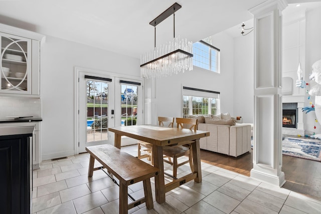 1022 Forest Hill Dr, Lawrenceburg, KY 40342 - dining room with light tile patterned flooring, a lit fireplace, french doors, a chandelier, and a high ceiling