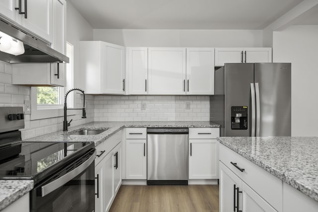 460 Spring St, Mt Sterling, KY 40353 - kitchen with appliances with stainless steel finishes, under cabinet range hood, white cabinets, and light wood-style floors