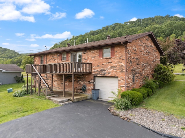 2299 Mcbrayer Rd, Clearfield, KY 40313 - rear view of house featuring a yard, a deck, an attached garage, and driveway