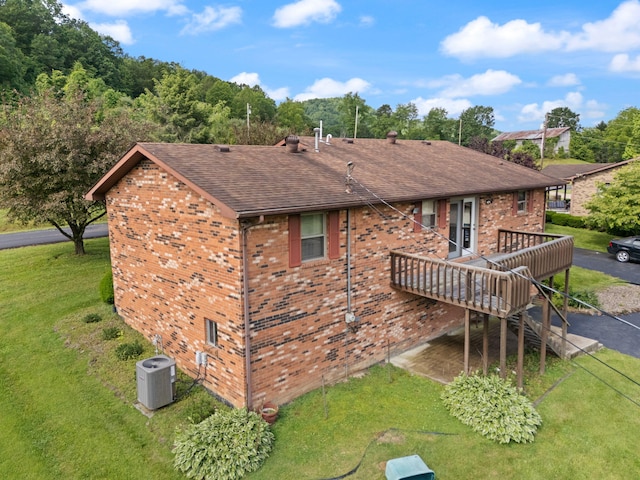 2299 Mcbrayer Rd, Clearfield, KY 40313 - rear view of house featuring brick siding, a wooden deck, a shingled roof, and a lawn