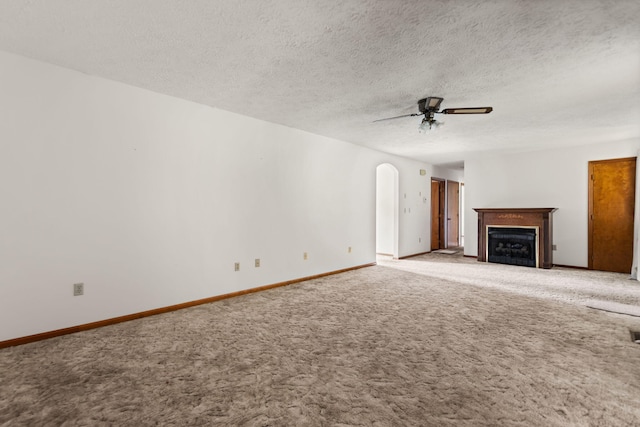 2299 Mcbrayer Rd, Clearfield, KY 40313 - unfurnished living room with ceiling fan, carpet, a fireplace, arched walkways, and a textured ceiling