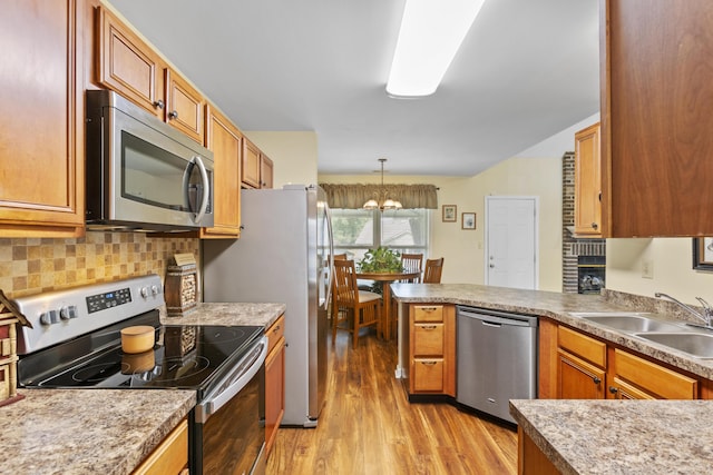 102 Dickinson Ct, Georgetown, KY 40324 - kitchen featuring stainless steel appliances, light wood-style flooring, a peninsula, decorative backsplash, and a chandelier
