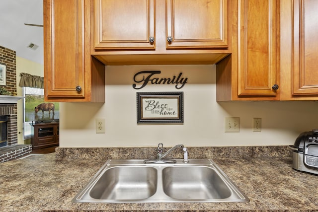 102 Dickinson Ct, Georgetown, KY 40324 - kitchen with a fireplace, dark countertops, and brown cabinetry
