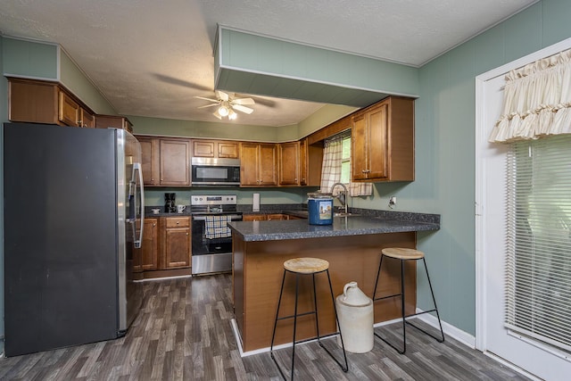 1390 Ky Highway 698, Stanford, KY 40484 - kitchen with appliances with stainless steel finishes, a peninsula, dark wood-style flooring, dark countertops, and a textured ceiling
