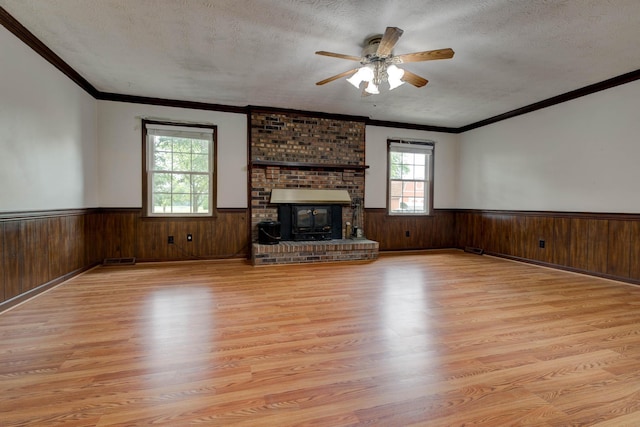 230 Fairway Dr, Nicholasville, KY 40356 - unfurnished living room featuring wainscoting, light wood-type flooring, a textured ceiling, a ceiling fan, and wooden walls