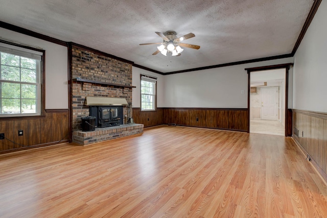 230 Fairway Dr, Nicholasville, KY 40356 - unfurnished living room with wainscoting, wood finished floors, a wood stove, ceiling fan, and a textured ceiling