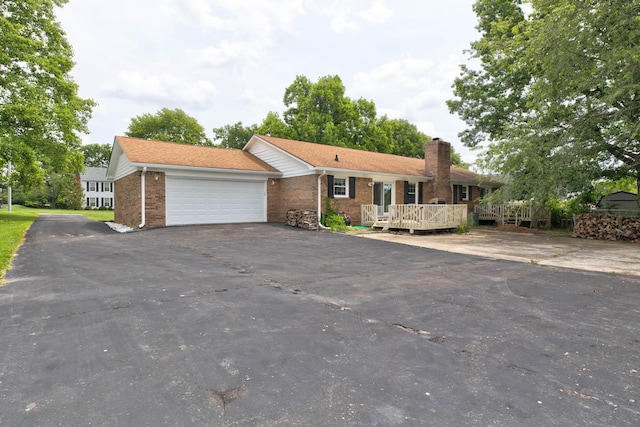 230 Fairway Dr, Nicholasville, KY 40356 - ranch-style home with an attached garage, asphalt driveway, a chimney, brick siding, and a wooden deck