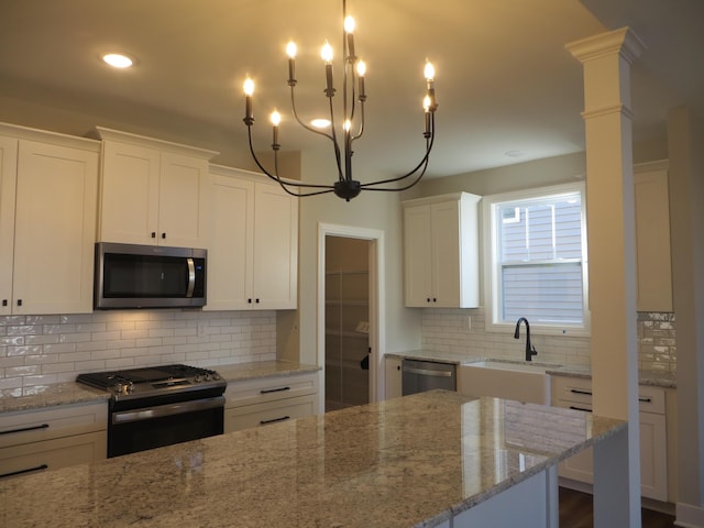 1210 Twilight Shadow Dr, Lexington, KY 40509 - kitchen with stainless steel appliances, a sink, white cabinets, a chandelier, and decorative backsplash
