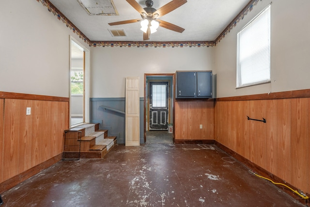 15 Conlee Ln, Stanton, KY 40380 - spare room with wainscoting, wooden walls, concrete floors, ceiling fan, and stairway