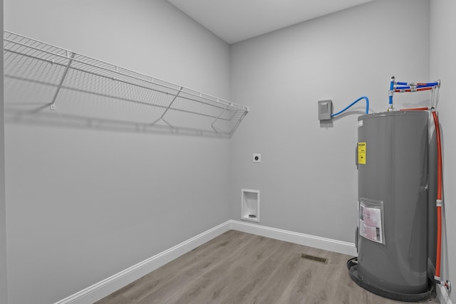 437 Boones Creek Rd, Lancaster, KY 40444 - laundry room with electric water heater, electric dryer hookup, light wood-style flooring, and baseboards