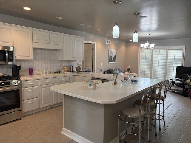 260 Beech Fork Blvd, Clay City, KY 40312 - kitchen featuring appliances with stainless steel finishes, light tile patterned flooring, a breakfast bar area, white cabinetry, and light countertops