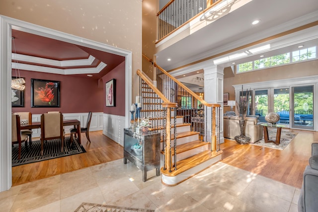 315 Whispering Brook Dr, Nicholasville, KY 40356 - stairs featuring decorative columns, a towering ceiling, tile patterned flooring, crown molding, and wainscoting