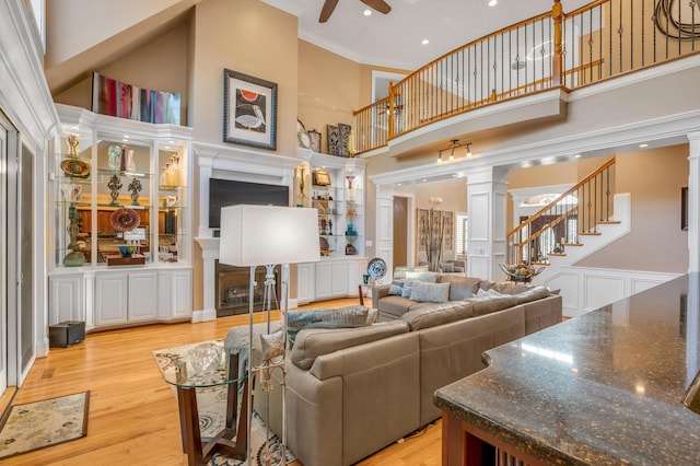 315 Whispering Brook Dr, Nicholasville, KY 40356 - living area featuring decorative columns, a ceiling fan, a fireplace, a towering ceiling, and stairs