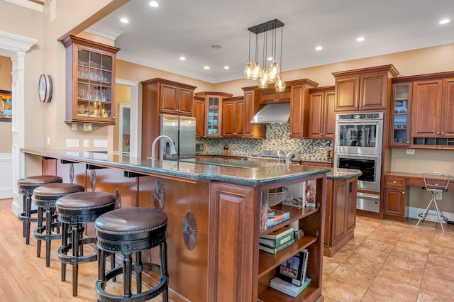 315 Whispering Brook Dr, Nicholasville, KY 40356 - kitchen with stainless steel appliances, a warming drawer, under cabinet range hood, brown cabinets, and a kitchen bar