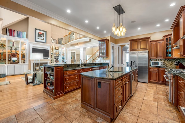 315 Whispering Brook Dr, Nicholasville, KY 40356 - kitchen featuring appliances with stainless steel finishes, ornamental molding, a kitchen island with sink, dark stone countertops, and a peninsula