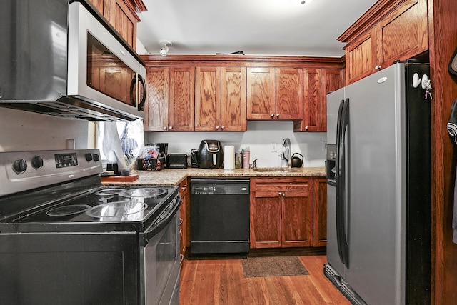 224 E Higgins St, Midway, KY 40347 - kitchen with stainless steel appliances, dark wood-style floors, brown cabinets, and light stone countertops