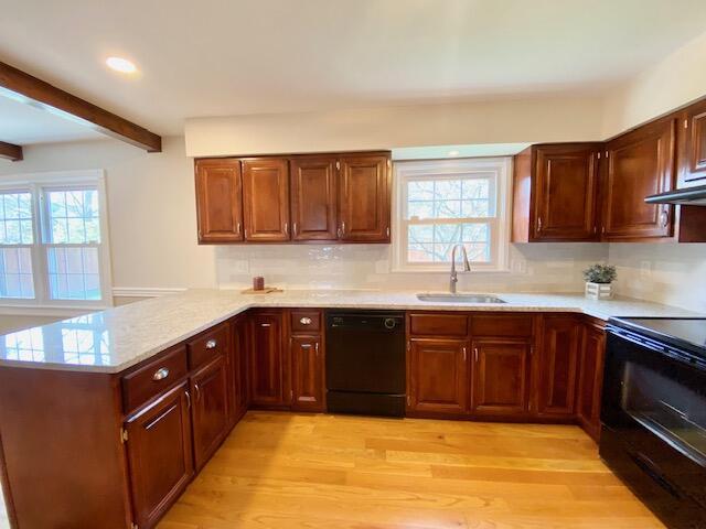2929 Waco Rd, Lexington, KY 40503 - kitchen with black appliances, a peninsula, beam ceiling, light countertops, and light wood finished floors