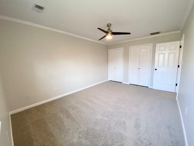 2929 Waco Rd, Lexington, KY 40503 - unfurnished bedroom featuring two closets, carpet flooring, crown molding, and a ceiling fan