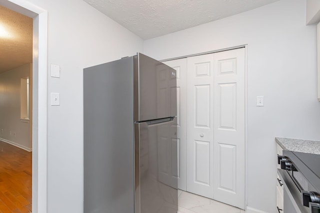 421 Redding Rd Unit 99, Lexington, KY 40517 - kitchen with freestanding refrigerator, a textured ceiling, light countertops, and light wood-style floors