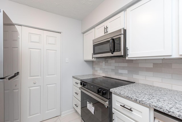 421 Redding Rd Unit 99, Lexington, KY 40517 - kitchen with stainless steel microwave, black range with electric cooktop, refrigerator, backsplash, and light stone countertops