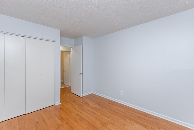 421 Redding Rd Unit 99, Lexington, KY 40517 - unfurnished bedroom with light wood-style floors, a closet, and a textured ceiling
