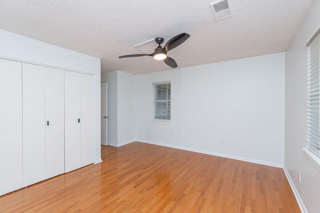 421 Redding Rd Unit 99, Lexington, KY 40517 - unfurnished bedroom with light wood-style floors, a closet, a textured ceiling, and a ceiling fan