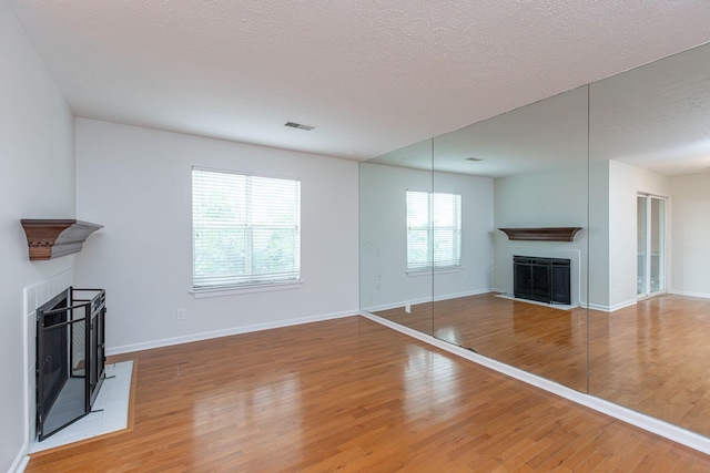 421 Redding Rd Unit 99, Lexington, KY 40517 - unfurnished living room with a fireplace, wood finished floors, and a textured ceiling