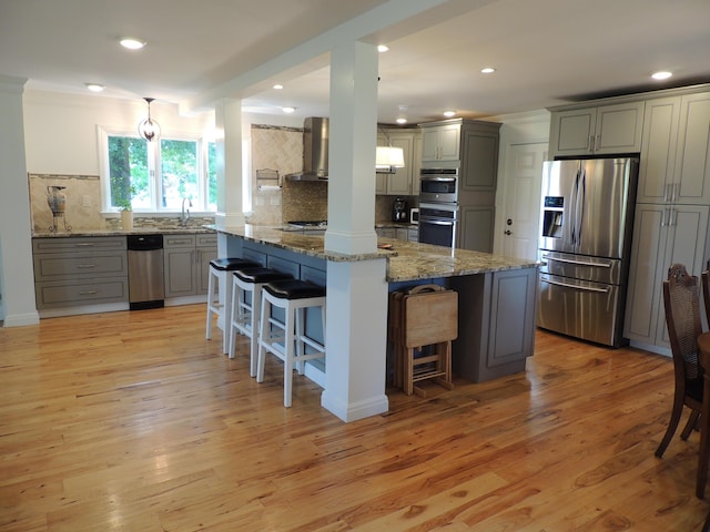 13 Scotland Dr, Frankfort, KY 40601 - kitchen featuring appliances with stainless steel finishes, wall chimney range hood, gray cabinets, tasteful backsplash, and a kitchen breakfast bar
