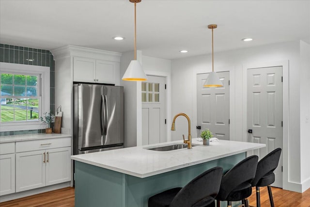 2940 Southview Dr, Lexington, KY 40503 - kitchen with freestanding refrigerator, a kitchen bar, white cabinets, light wood-type flooring, and recessed lighting