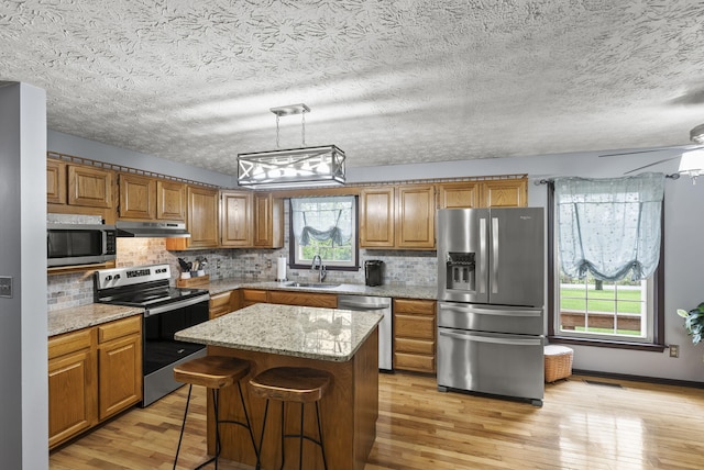 1651 Waits Rd, Cynthiana, KY 41031 - kitchen featuring appliances with stainless steel finishes, under cabinet range hood, brown cabinets, and a textured ceiling
