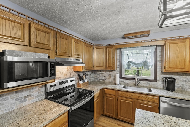 1651 Waits Rd, Cynthiana, KY 41031 - kitchen with appliances with stainless steel finishes, under cabinet range hood, decorative backsplash, light stone counters, and brown cabinetry