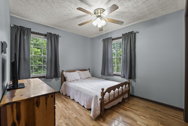 1651 Waits Rd, Cynthiana, KY 41031 - bedroom featuring multiple windows, light wood-style flooring, a textured ceiling, and a ceiling fan