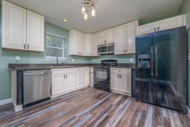 242 Possum Ridge Rd, West Liberty, KY 41472 - kitchen with black appliances, wood finished floors, a textured ceiling, and dark stone counters