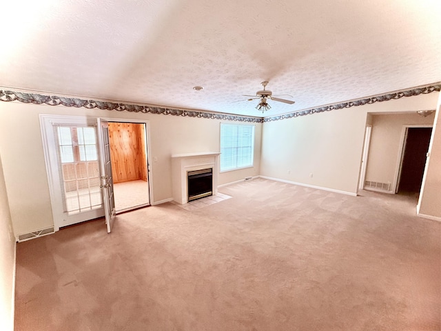 1012 Heathcliff Dr, Richmond, KY 40475 - unfurnished living room with healthy amount of natural light, ceiling fan, a fireplace with flush hearth, a textured ceiling, and light carpet